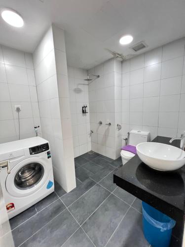 Un baño con lavadora y lavabo. en Chambers Residence by Gloria Homes, en Kuala Lumpur