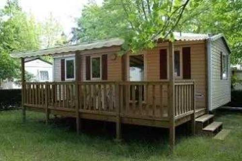 a wooden house with a deck in the grass at ZEcamping 4 étoiles chiens acceptés bien-être piscine couverte in Azur