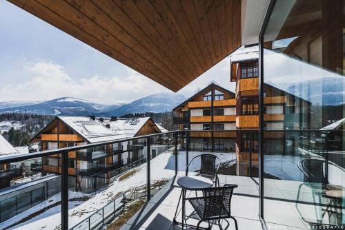 einen Balkon mit Stühlen und Bergblick in der Unterkunft Tremonti Hotel Karpacz in Karpacz