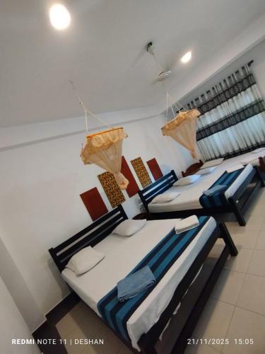 eine Gruppe von vier Betten in einem Zimmer in der Unterkunft Hotel Senora in Kataragama