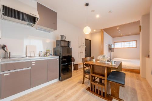 eine Küche und ein Esszimmer mit Tisch und ein Schlafzimmer in der Unterkunft O's Apartment Hotel In Kyobashi 3FA in Osaka