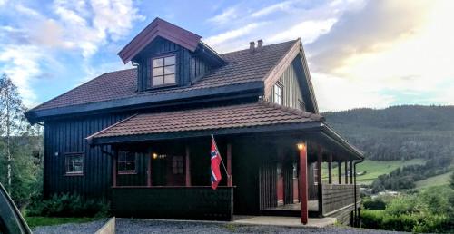 ein Haus mit einer Flagge auf der Vorderseite in der Unterkunft Skap Opplevelser! in Svingvoll