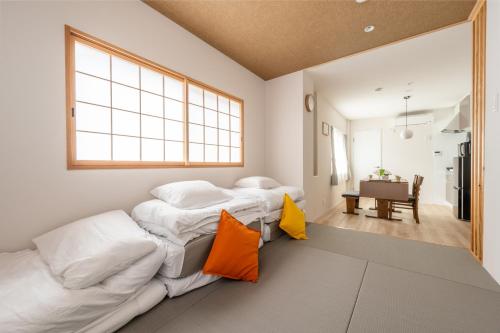 zwei Betten in einem Zimmer mit Küche und Tisch in der Unterkunft O's Apartment Hotel In Kyobashi 3FA in Osaka