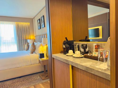 a hotel room with a bed and a counter with a kitchen at InterContinental Lusaka by IHG in Lusaka