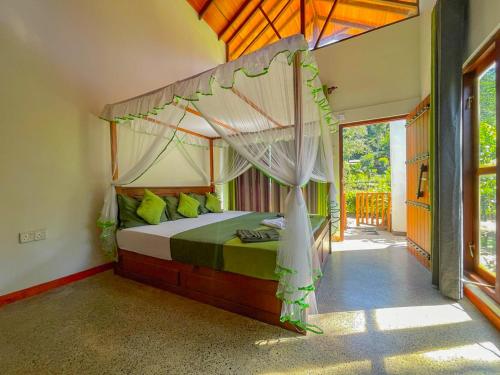 een slaapkamer met een hemelbed bij Sinharaja Rainforest Vibe in Deniyaya