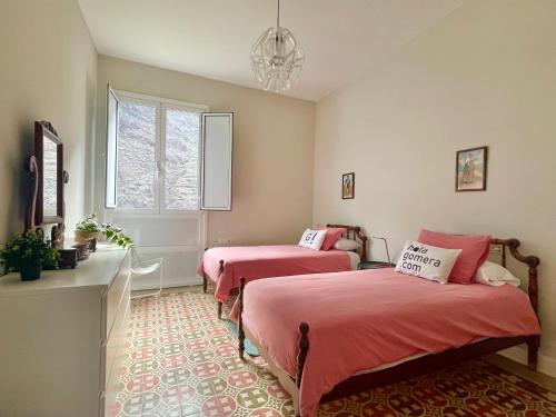 een slaapkamer met twee bedden en een raam bij Casa Orijamas in Calera
