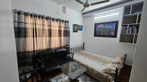 una sala de estar con un sofá y una silla en Sky Garden Home, en Dhaka
