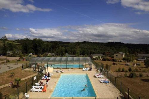 une piscine avec des gens qui se prélassent dans des chaises autour dans l'établissement Chalet 3 étoiles - Piscine - eebbhf, à Beynat