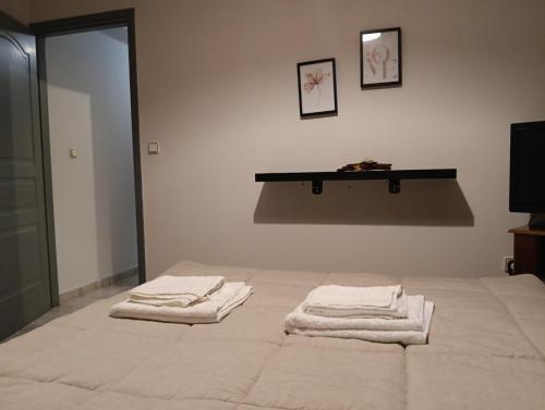 a bedroom with a bed with towels on it at H&V suite home in Paralía Avlídhos