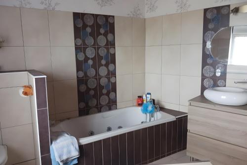a bathroom with a tub and a sink at Maison en bord de mer in Réville