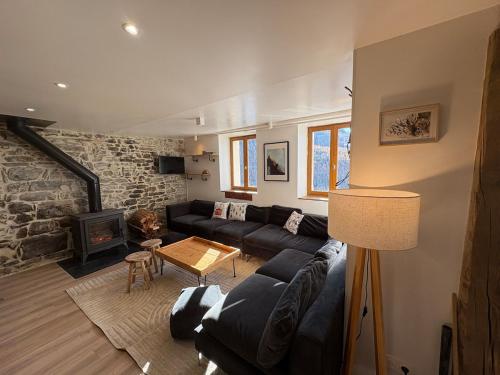 ein Wohnzimmer mit Couch und Kamin in der Unterkunft Camp de Base - retraite d'exception 16 personnes in Les Orres