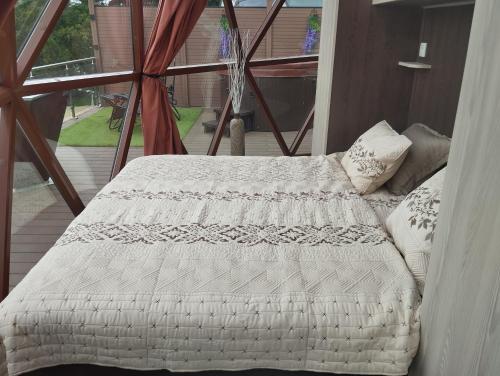 a bed with a white blanket on a balcony at Glamping Bříza in Cheb