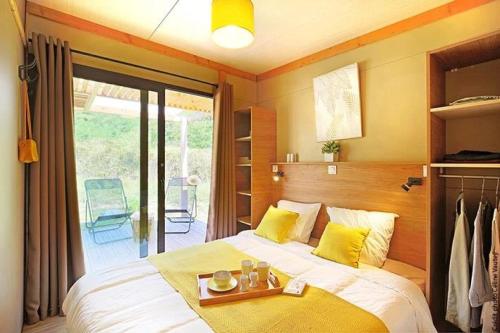 een slaapkamer met een bed met een dienblad erop bij Chalet 3 étoiles - Piscine - eeigai in Darbres