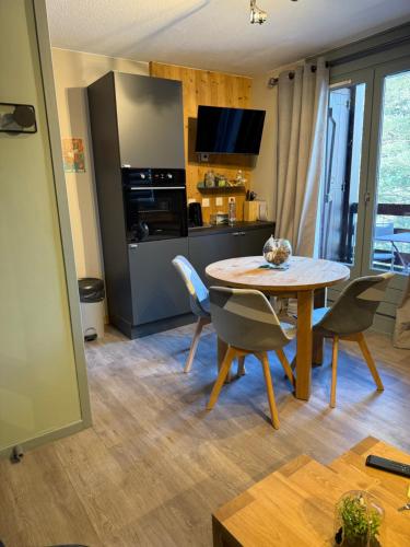 eine Küche und ein Esszimmer mit Tisch und Stühlen in der Unterkunft Logement cosy à la montagne in Bourg-Saint-Maurice