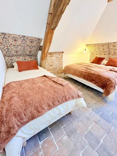 una camera da letto con due letti e un muro di mattoni di L'Ecrin Saint Denis, petite au centre d'Amboise! a La Celle-sous-Gouzon