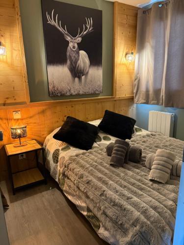 ein Schlafzimmer mit einem Bett mit einem Hirsch an der Wand in der Unterkunft Logement cosy à la montagne in Bourg-Saint-Maurice