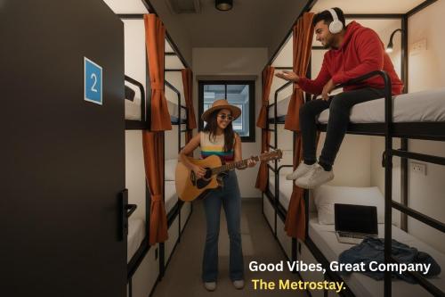 a man playing a guitar and a woman standing in a room at Metro POD Hotel at New Delhi Metro & Railway Station in New Delhi