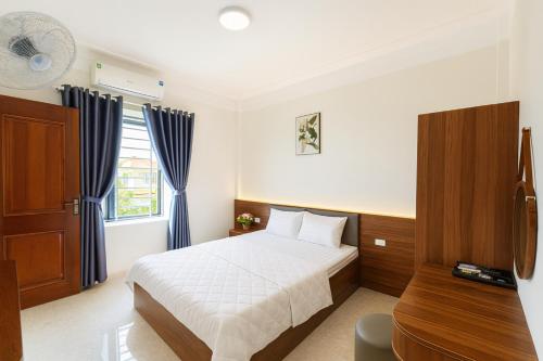 een slaapkamer met een bed, een bureau en een raam bij Visip Hotel in Vinh