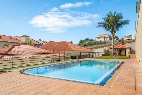 a swimming pool in a yard with a fence at Freitas House by Homie in Ponta do Sol