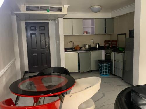 una pequeña cocina con una mesa y sillas en una habitación en Chibuzor Apartment, en Lagos