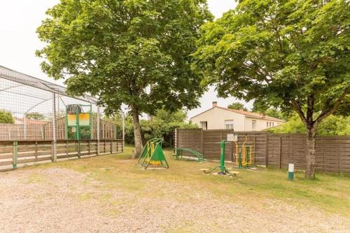 a park with a playground with two trees and a fence at ZEcamping 3 étoiles animé animaux acceptés familial piscine couverte in Avrillé