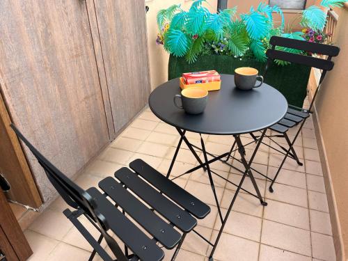 une petite table avec deux tasses et deux chaises dans l'établissement Kalon Eidos, il magico posto della Calabria Jonica, à Condofuri Marina