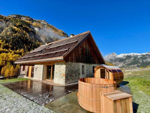 une petite maison avec un baril devant elle dans l'établissement Chalet prestige 14 pers au pied des pistes, à Ceillac