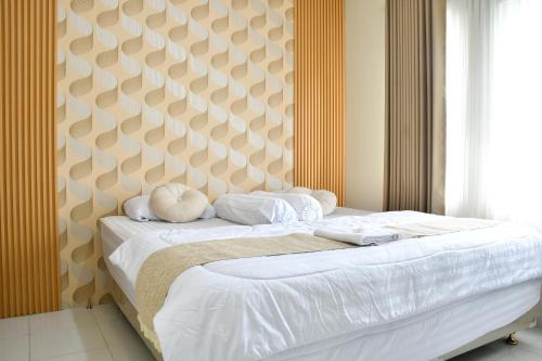 Un dormitorio con una cama grande con un cabecero grande. en Trasmambang, en Ngingas