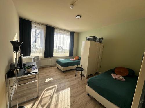 a small room with two beds and a refrigerator at Pension Moerdijk in Moerdijk