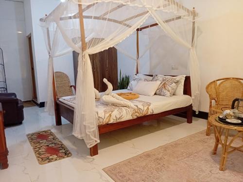 a bedroom with a bed with a canopy at Tamasha Mango House in Dickwella