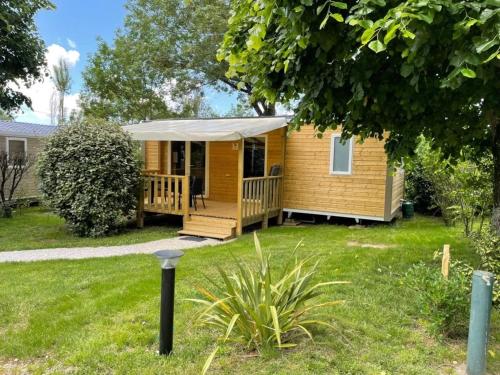 a small yellow house with a porch with a tent at Camping 3 étoiles - ccaaafd in Sorèze