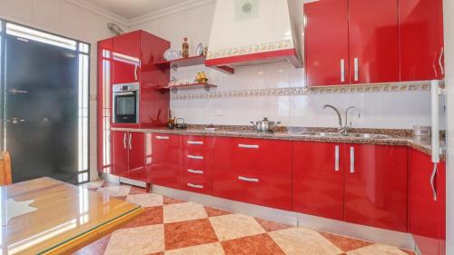 a red kitchen with red cabinets and a sink at Villa Josara by Ruralidays in Huelva