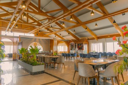 un restaurant avec des plafonds en bois, des tables et des chaises dans l'établissement Humming Bird Resort and Executive Suites, à Murree