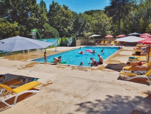 un groupe de personnes dans une piscine d'un complexe hôtelier dans l'établissement Camping 3 étoiles - Parc aquatique - ccbbeec, à Beaumont-du-Périgord