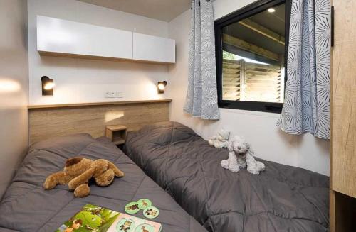 zwei ausgestopfte Tiere auf einem Bett in einem Schlafzimmer in der Unterkunft Chalet 4 étoiles - Piscine - ccafdif in Loupiac