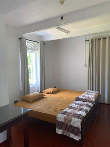 a bedroom with a large bed with a window at Cityscape Bungalow in Bandarawela