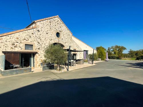 ein großes Steingebäude mit einer Straße davor in der Unterkunft "La Petite Félixière" à 25 min du Puy du Foù, 10 min de Cholet, et 35 min de Nantes in Saint-André-de-la-Marche