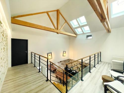 un aménagement de combles avec un escalier et une porte noire dans l'établissement "La Petite Félixière" à 25 min du Puy du Foù, 10 min de Cholet, et 35 min de Nantes, à Saint-André-de-la-Marche