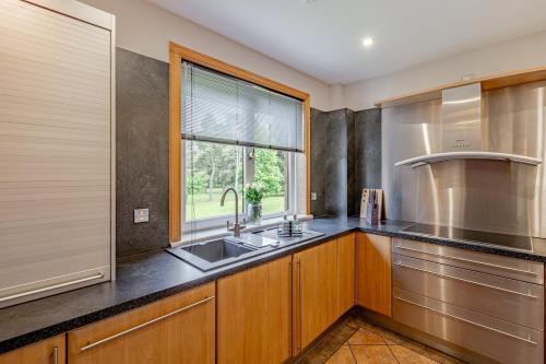 une cuisine avec un évier et une fenêtre dans l'établissement Spacious Gleneagles Apartment, 