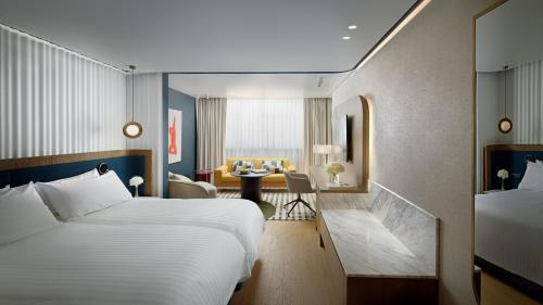 a hotel room with two beds and a desk at InterContinental Athenaeum Athens by IHG in Athens