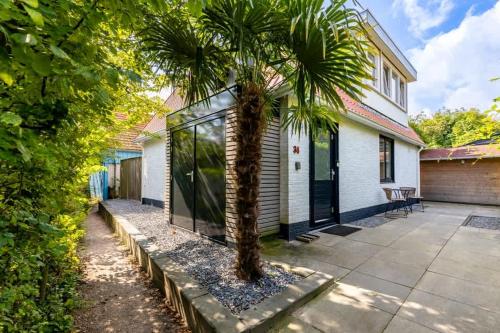 eine Palme vor einem Haus in der Unterkunft Hello Zeeland - Vroonweg 34 in Oostkapelle