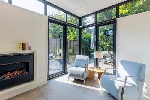 ein Wohnzimmer mit einem Kamin und 2 Stühlen in der Unterkunft Hello Zeeland - Vroonweg 34 in Oostkapelle