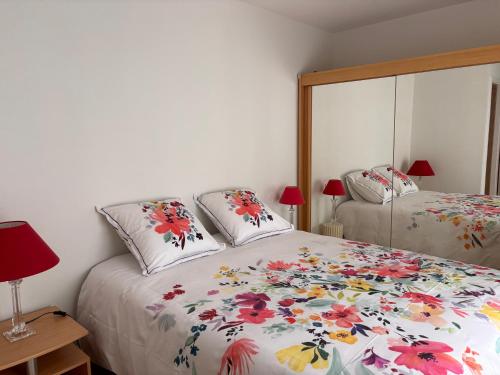 a bedroom with two beds and a mirror at Appartement Les Marguerites spa et spa de nage in Contrexéville