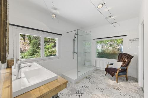 a bathroom with a tub and a shower and a chair at Villa vue mer panoramique & piscine chauffée in Toulon