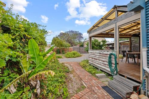 a garden with a wooden pergola and a patio at South Freo Bungalow - Hidden Spa Bath in South Fremantle