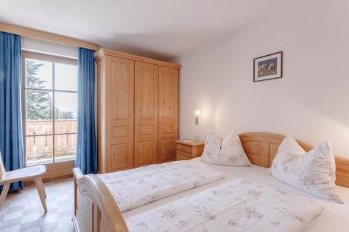 a bedroom with a bed and a large window at Villa Bernhard in Siusi