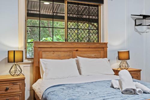 ein Schlafzimmer mit einem Bett mit zwei Lampen und einem Fenster in der Unterkunft South Freo Bungalow - Hidden Spa Bath in South Fremantle