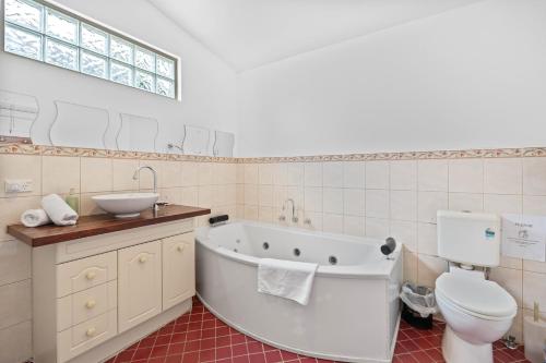 ein Badezimmer mit Badewanne, Toilette und Waschbecken in der Unterkunft South Freo Bungalow - Hidden Spa Bath in South Fremantle