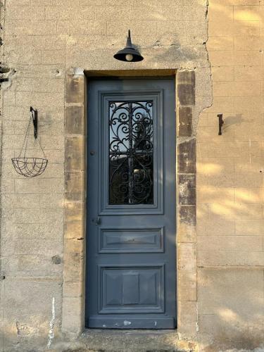 a blue door with a iron gate on a building at Maison authentique en bord de Meuse in Joigny-sur-Meuse