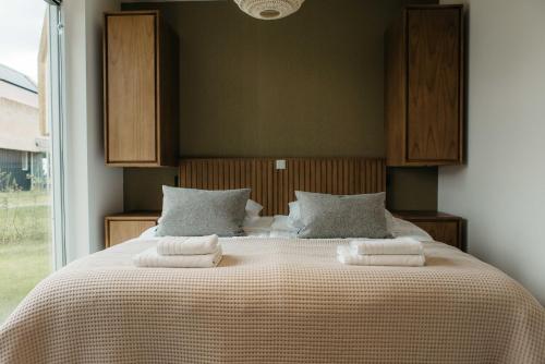 una camera da letto con un letto con due asciugamani sopra di Watervilla buitenzijde | 6 personen a Heeg